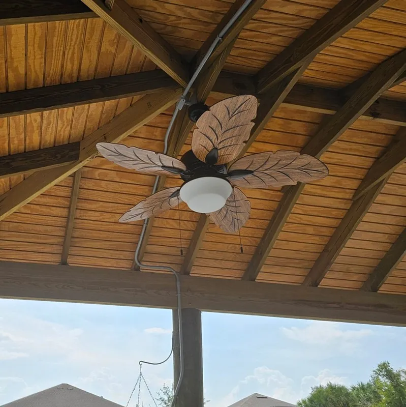 Ceiling fan and light under a wood-plank outdoor pavilion
